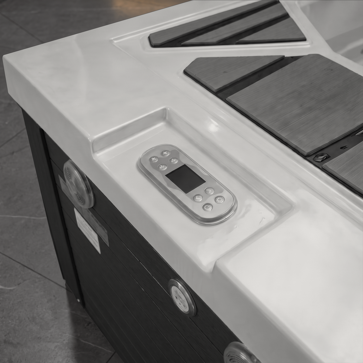 Close-up of a white and black hot tub cold plunge or spa control console, showing the remote control and exterior panel details.