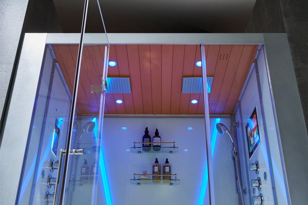 A modern steam shower with rainfall ceiling showers and storage shelving and entertainment screen with shower heads.