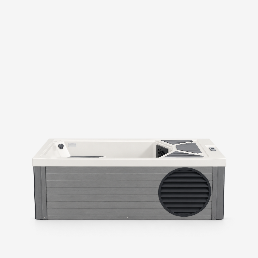 A modern rectangular cold plunge with a white interior and a gray exterior, featuring a black vent on the front and a small control panel on the top right.