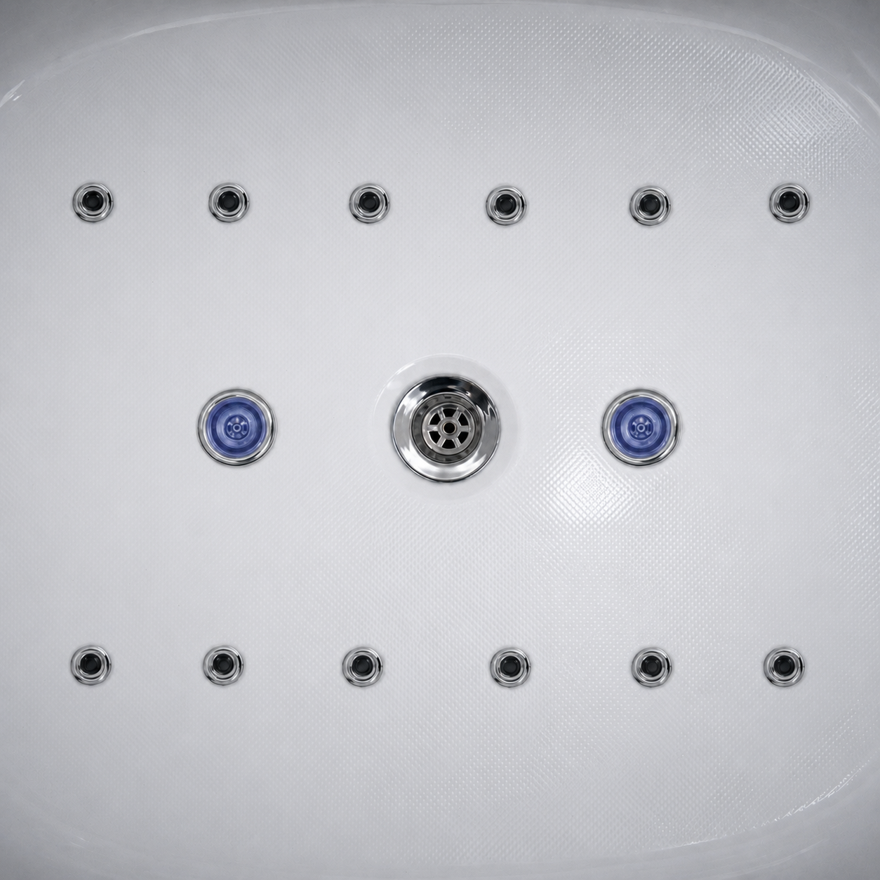 Close-up of a white spa or hot tub jet plate with multiple circular chrome jets and two blue-accented jets in the center row.